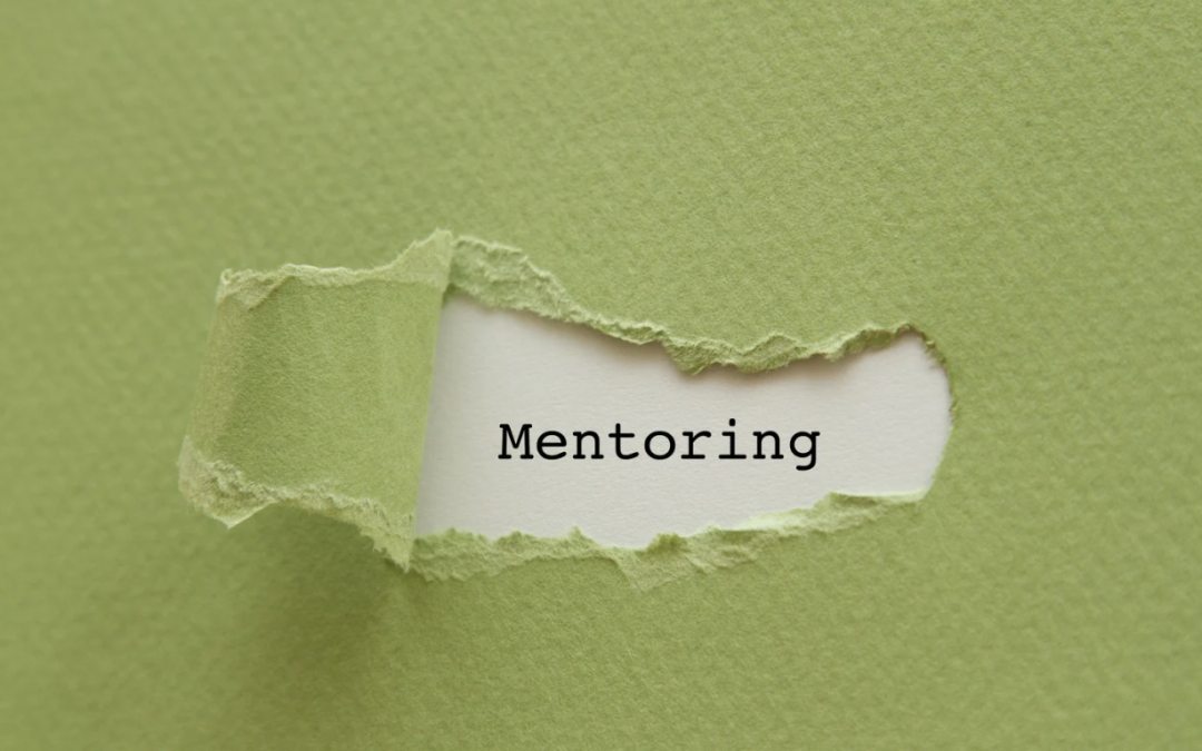 Das Wort Mentoring erscheint auf einer Papierflläche